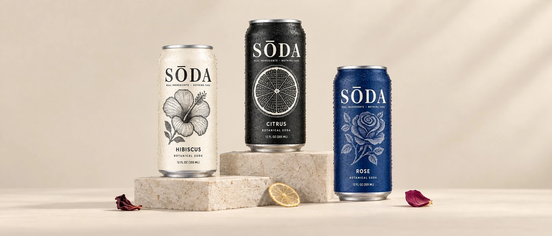 Three SŌDA botanical beverage cans in cream, black and cobalt.