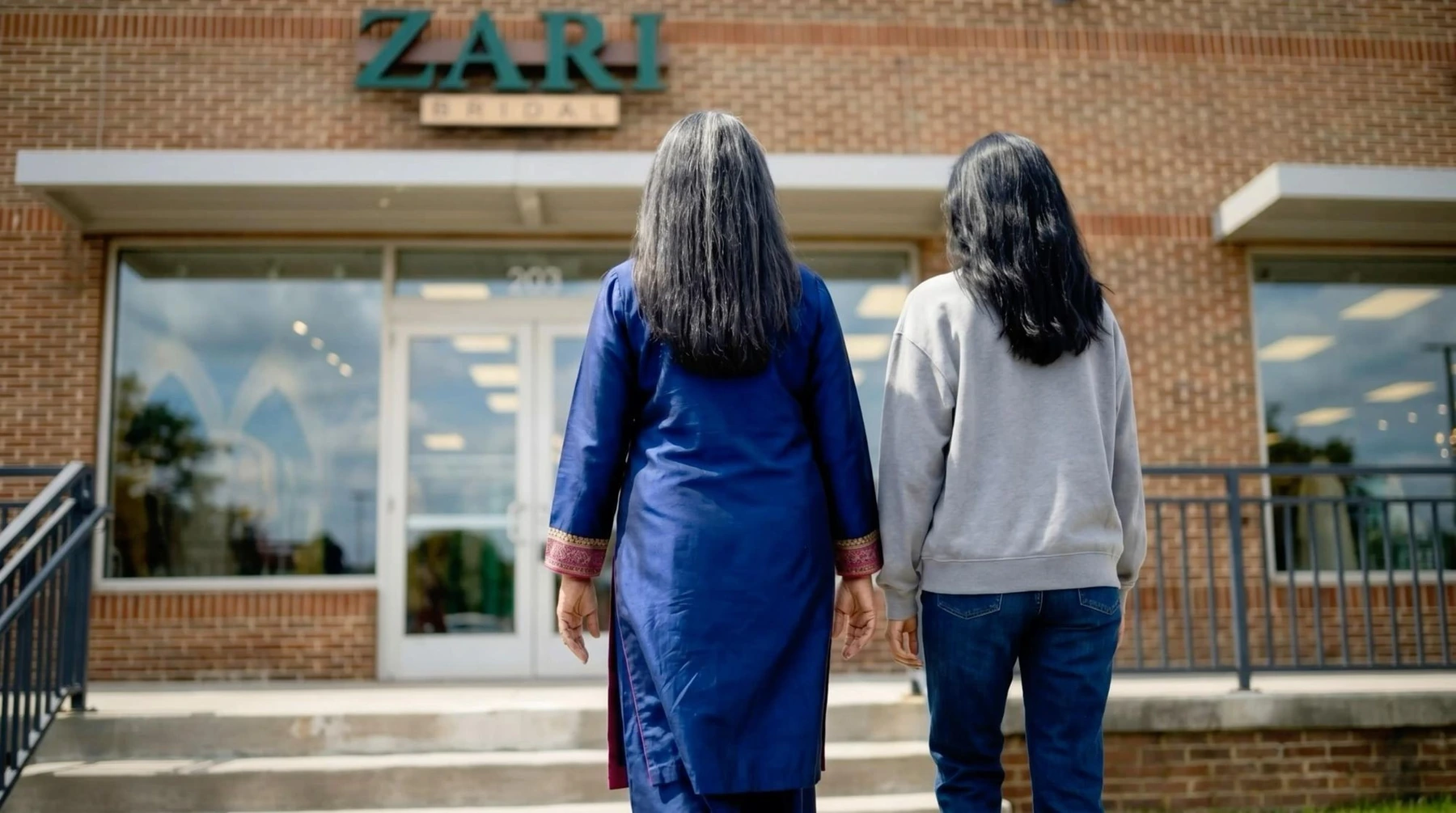 Two women seen from behind outside a building in Twenty Minutes.